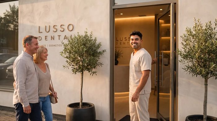 Dr Kal welcoming a couple at the LUSSO Dental front door